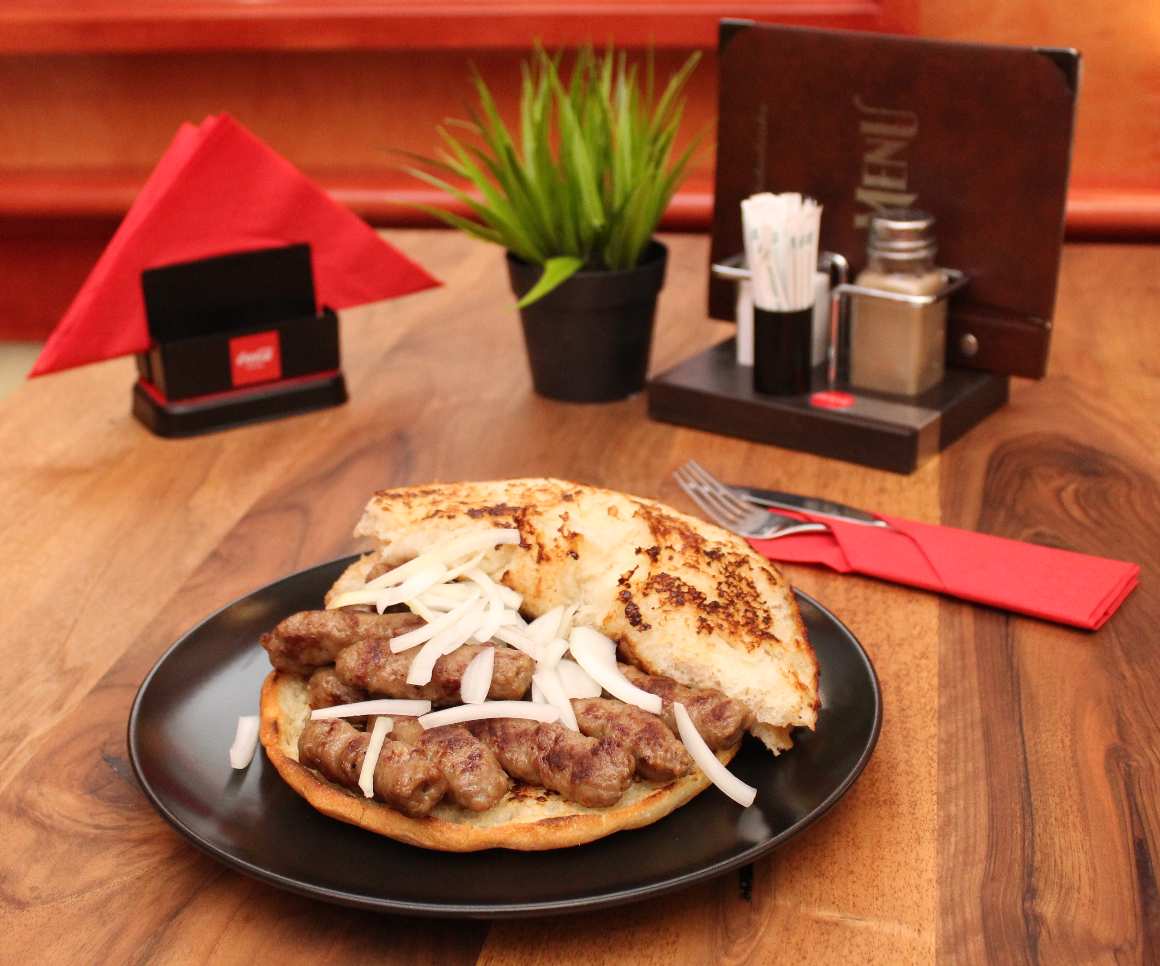 Ćevapi served with flatbread and onions