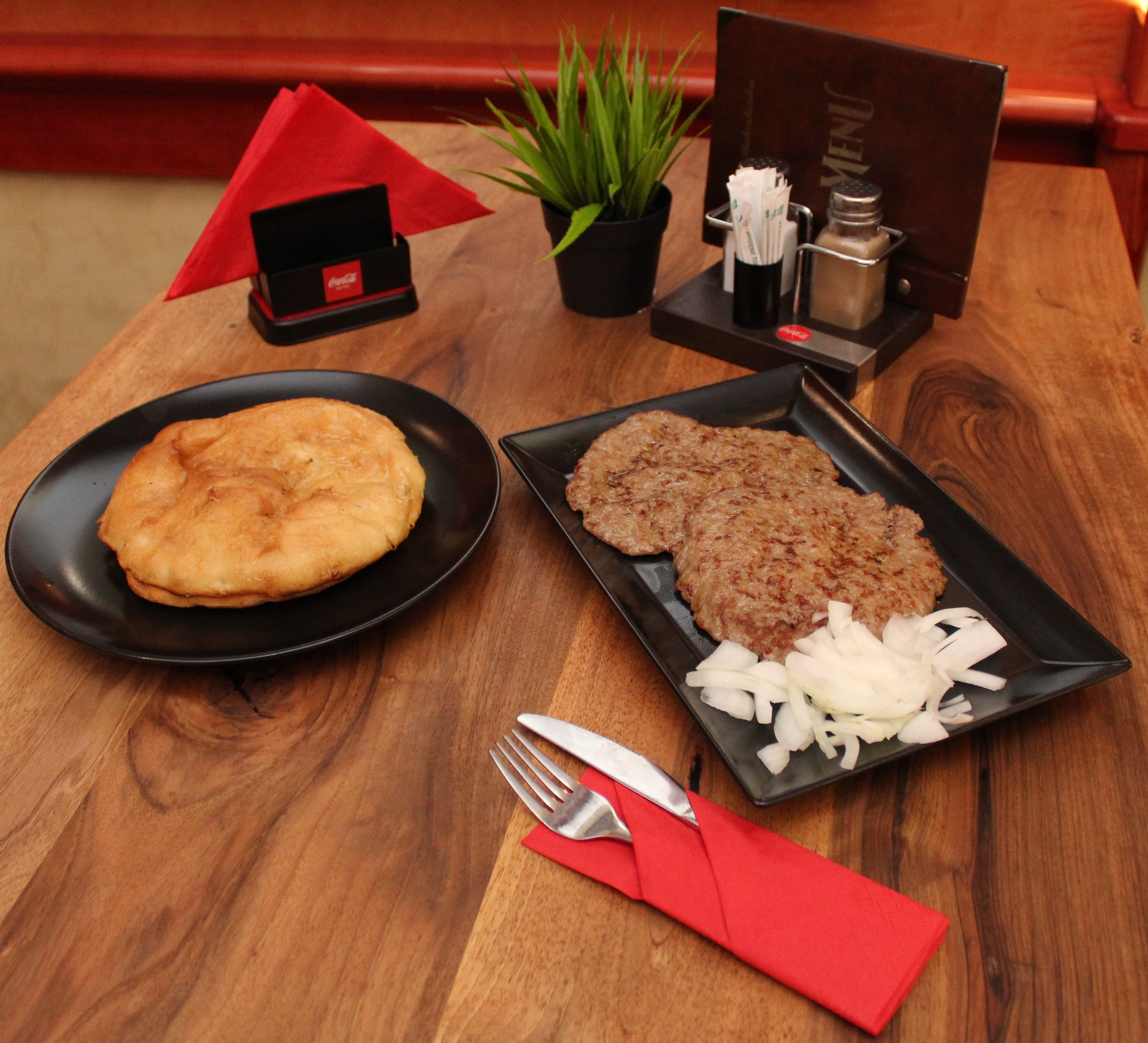 Pljeskavica served with flatbread and onions