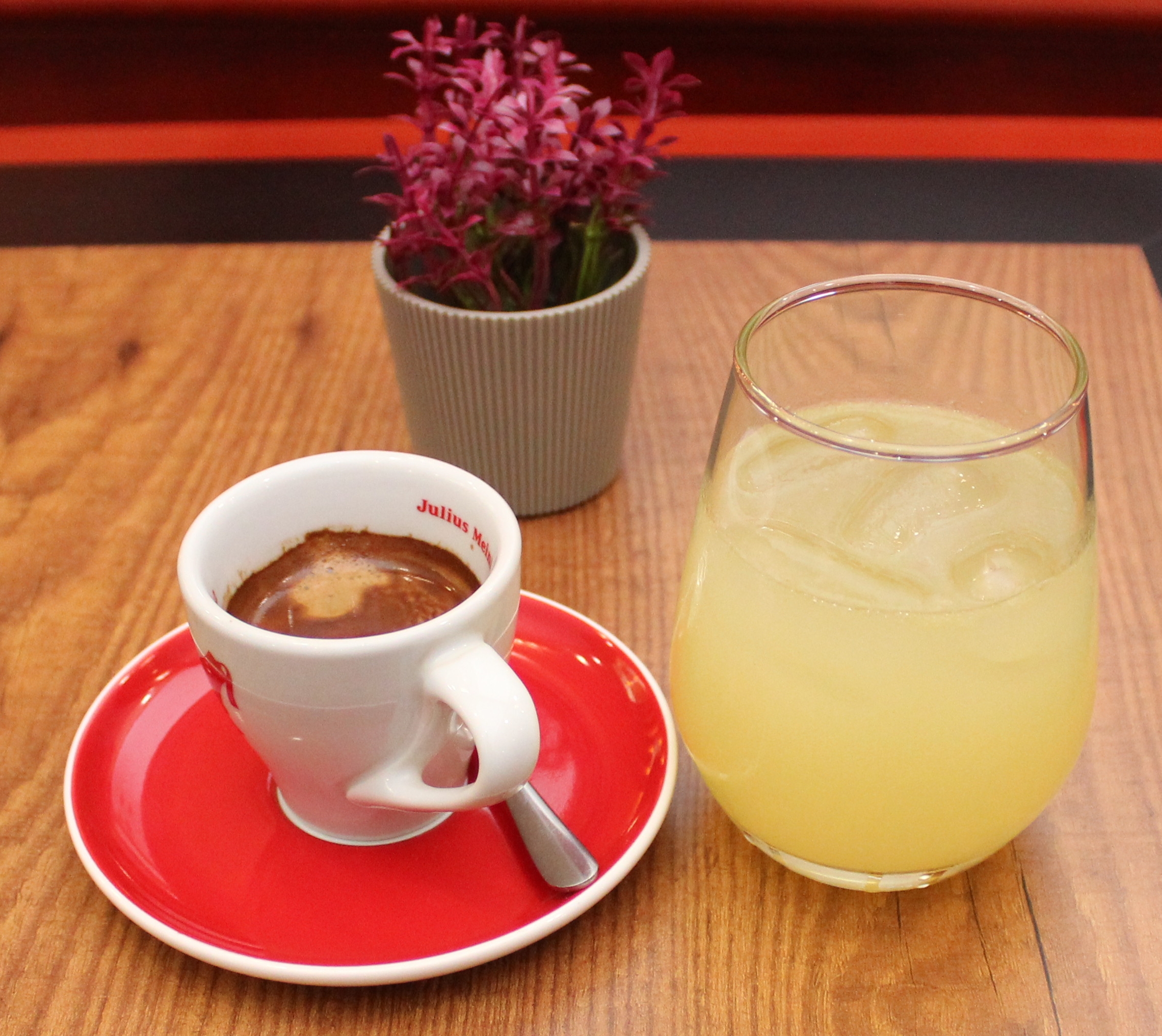 Espresso coffee in red cup with saucer