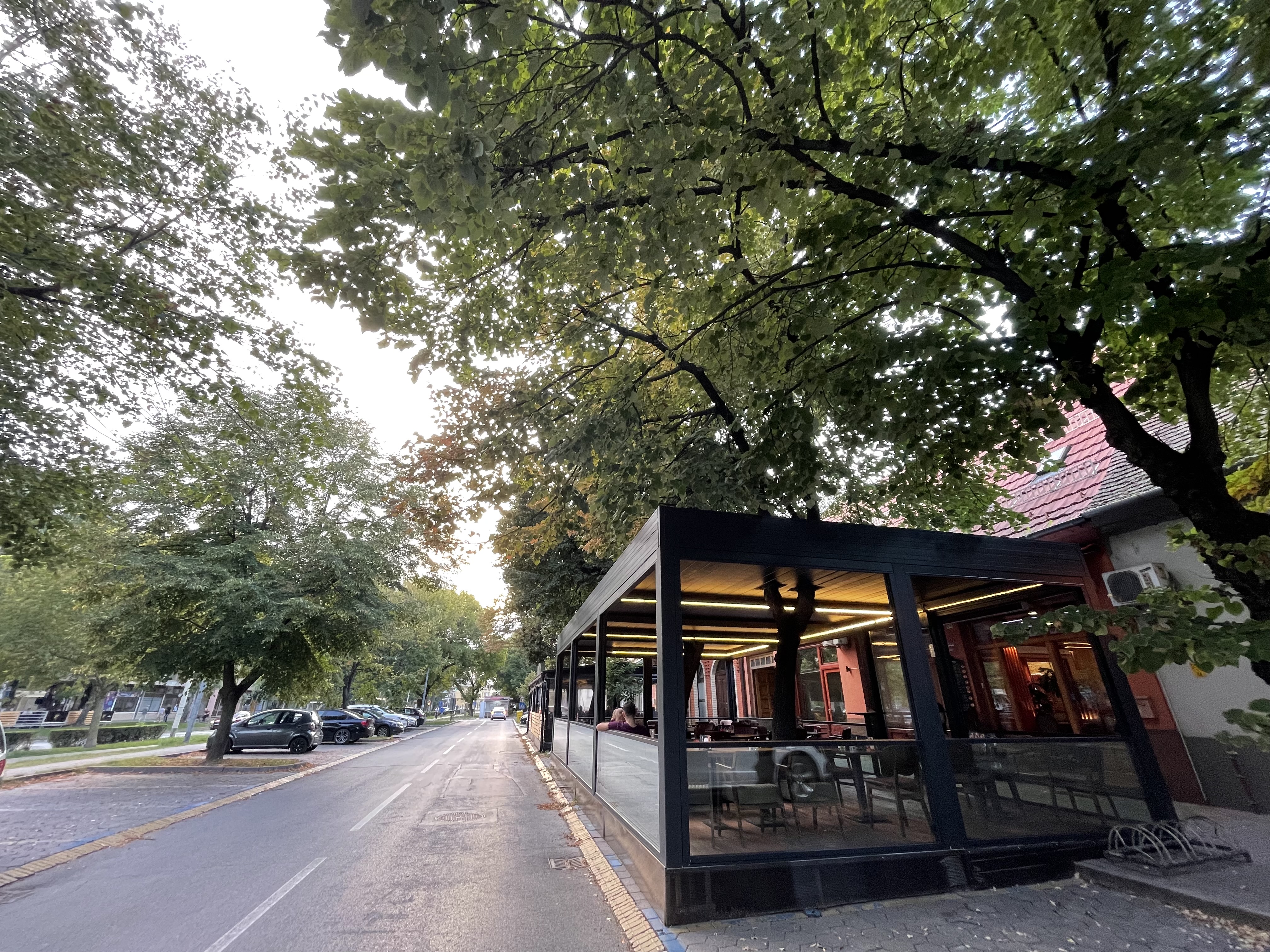 Inviting outdoor terrace seating with tree views and red Makedonka sign